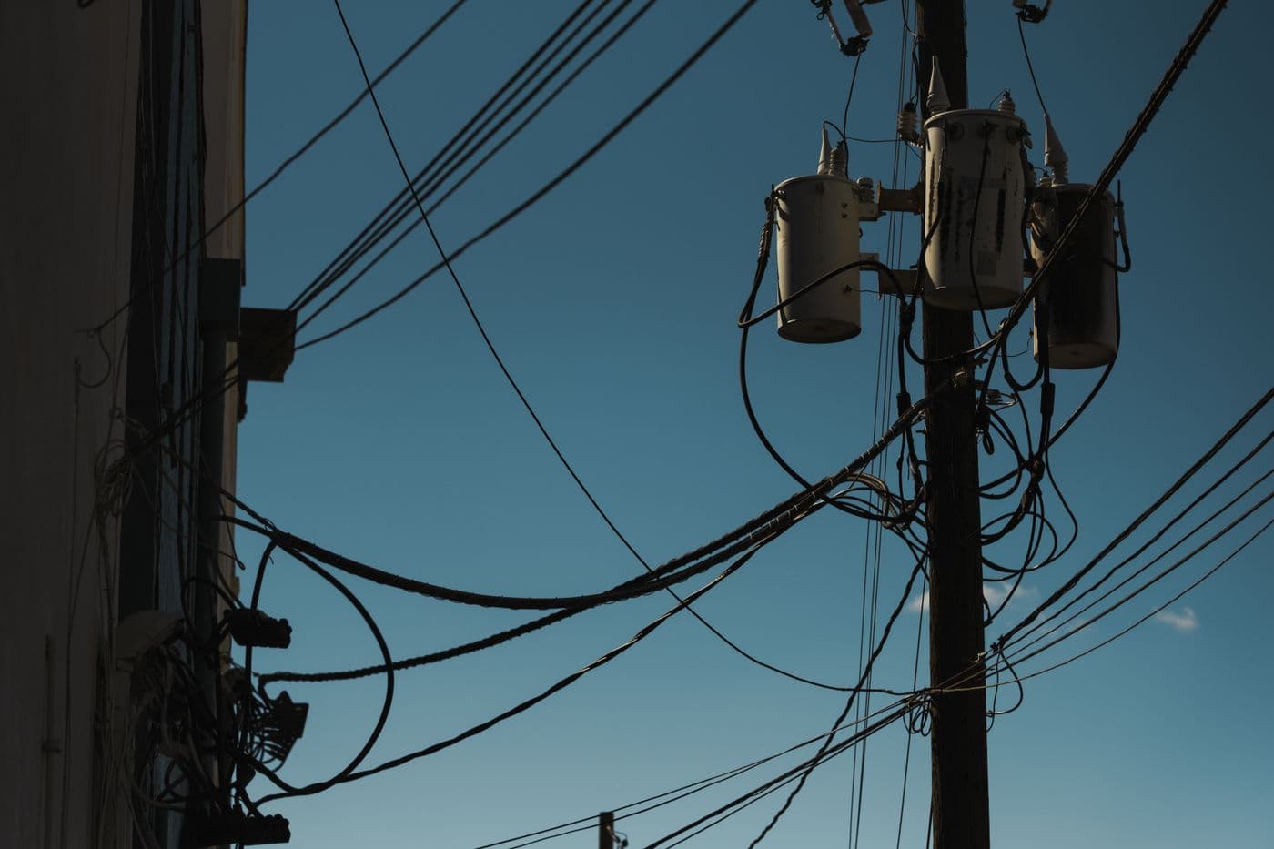 Power lines and transformers against a clear blue sky